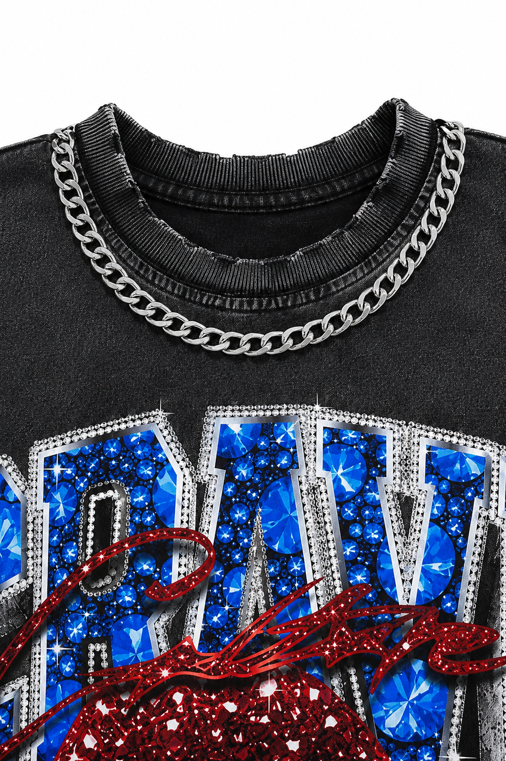 Close-up of a black graphic t-shirt featuring a silver chain print around the collar, large blue rhinestone-embellished letters, and a red glittery graphic at the bottom.
