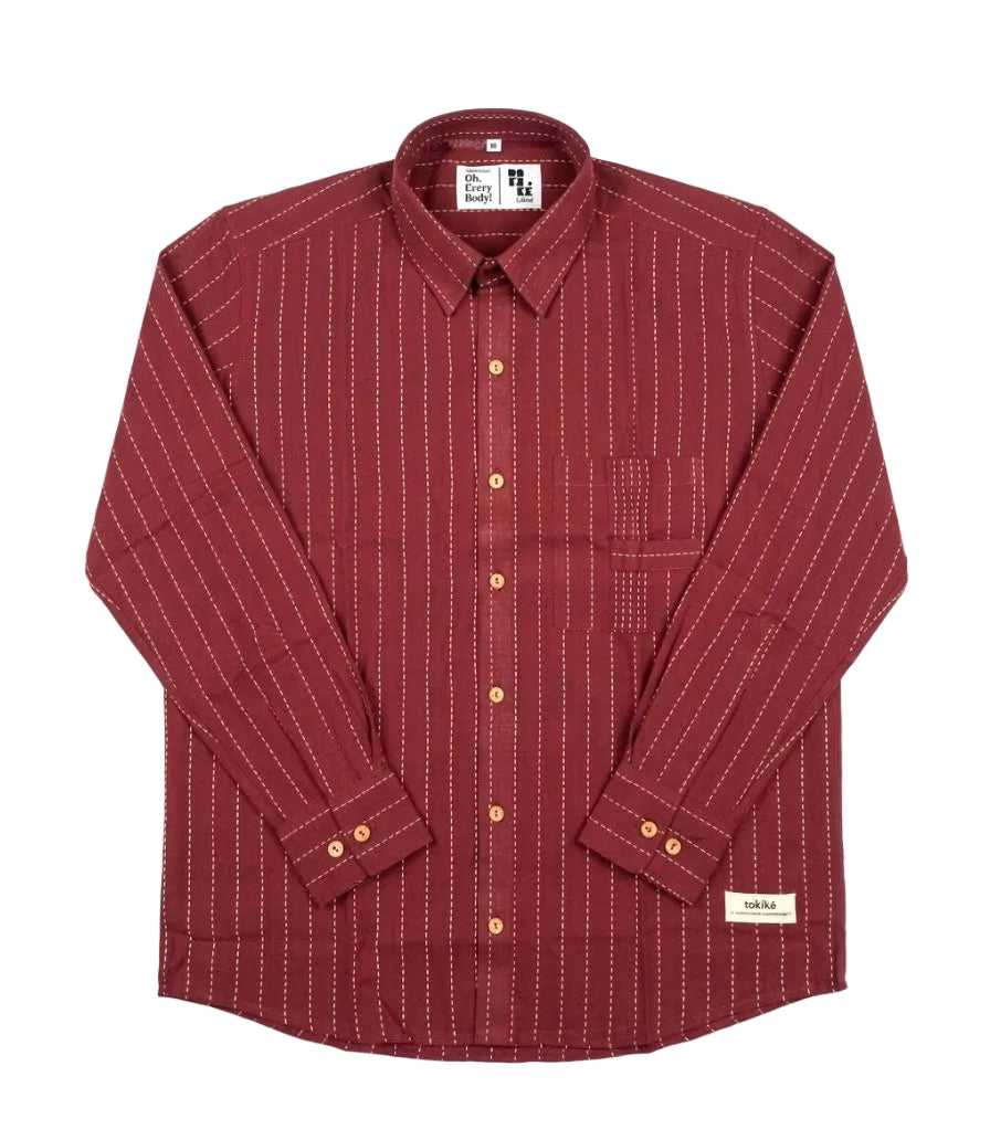 A long-sleeve button-up shirt in a deep burgundy red, featuring fine vertical white stripes and gold buttons, laid flat against a white background.