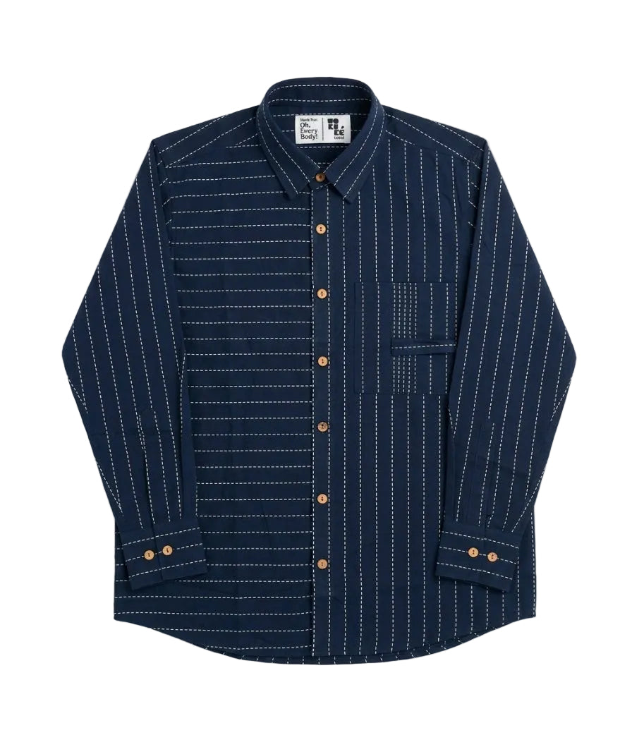 A long-sleeve button-up shirt in navy blue with thin white vertical pinstripes and brown buttons, laid flat against a light gray background.