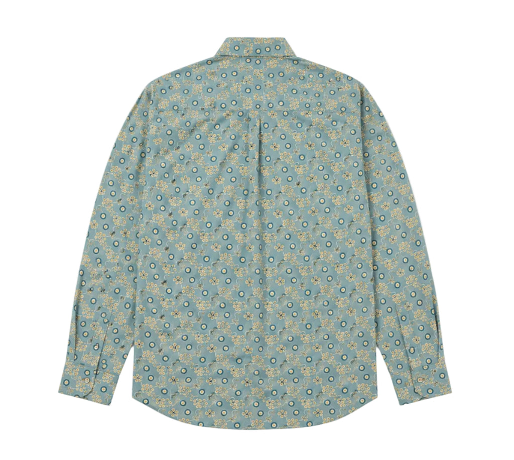 A long-sleeve button-up shirt with a repeating circular medallion pattern in teal, blue, and beige, shown flat against a light gray background.