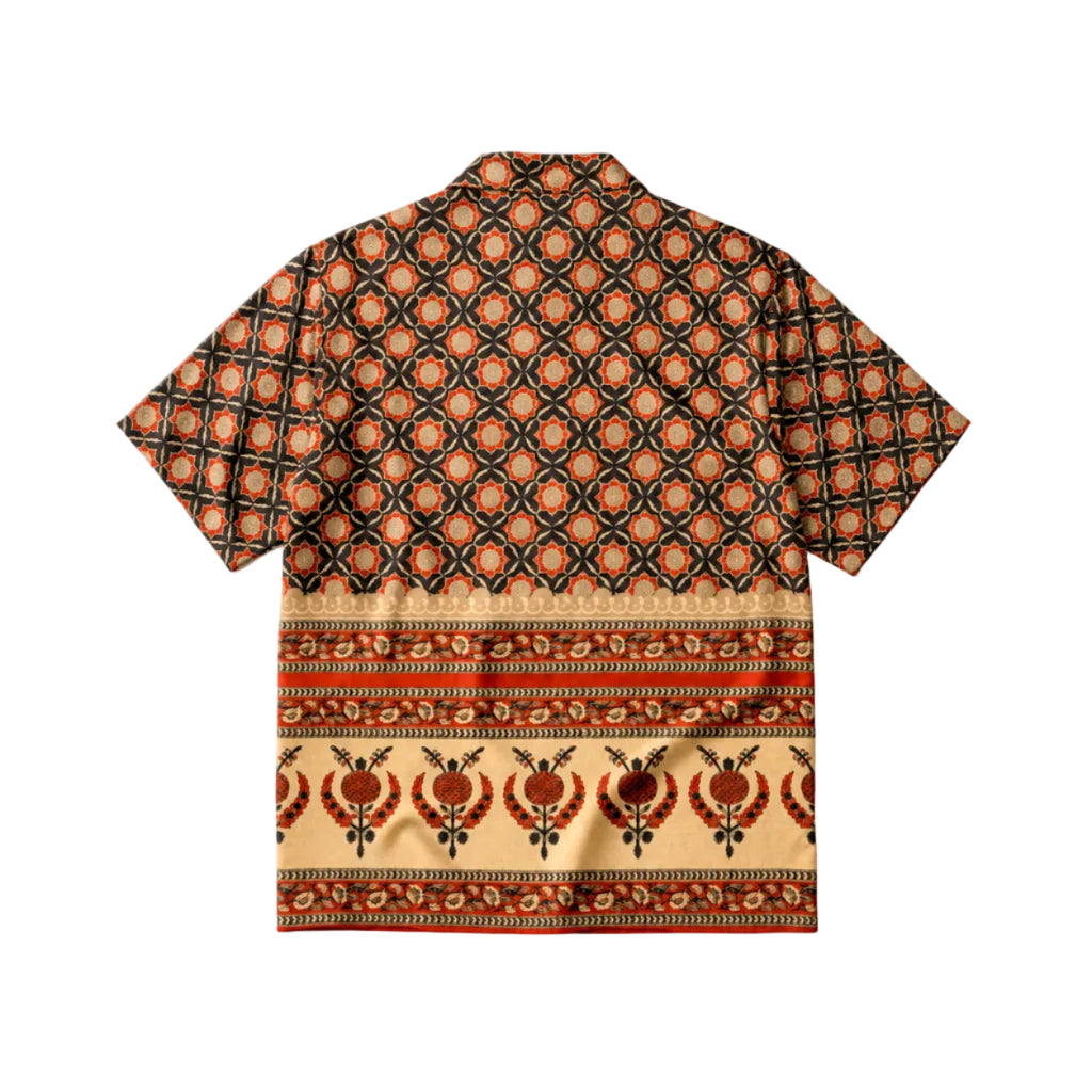 A short-sleeve camp collar shirt with a complex geometric and floral pattern in orange, brown, black, and beige, shown flat against a white background.
